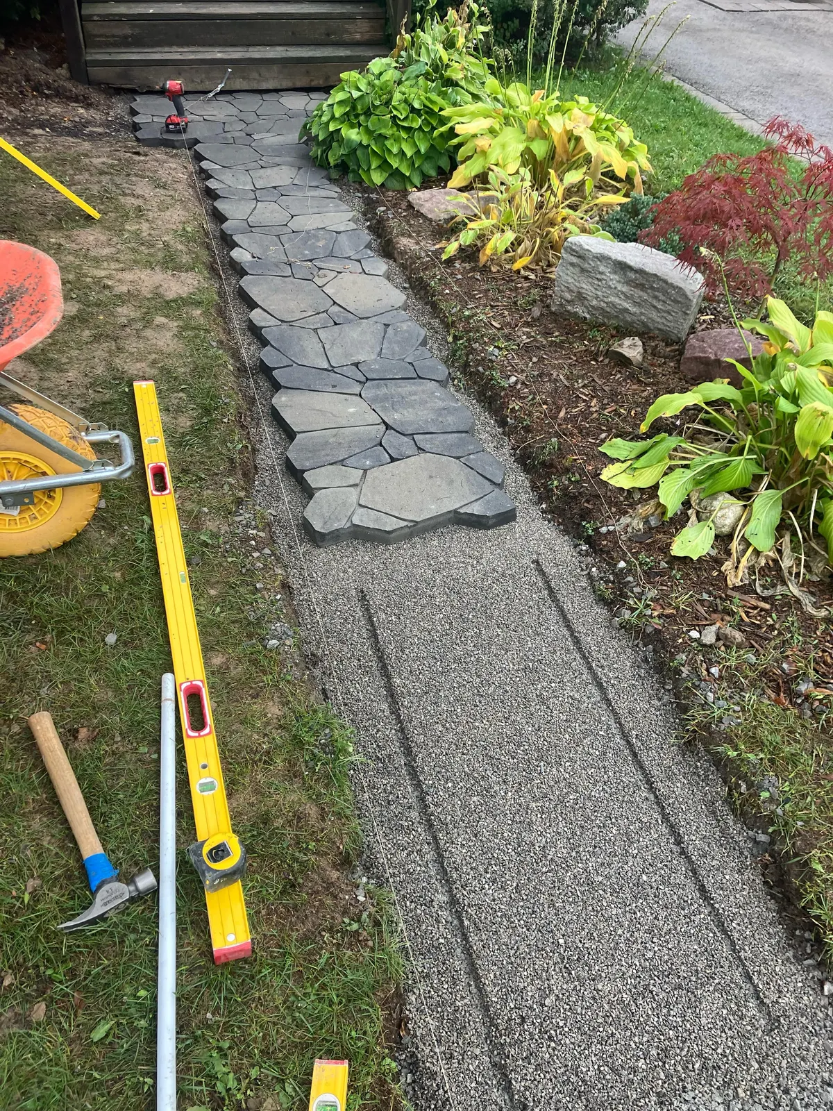 Paver-stone walkway under construction with gravel base and level